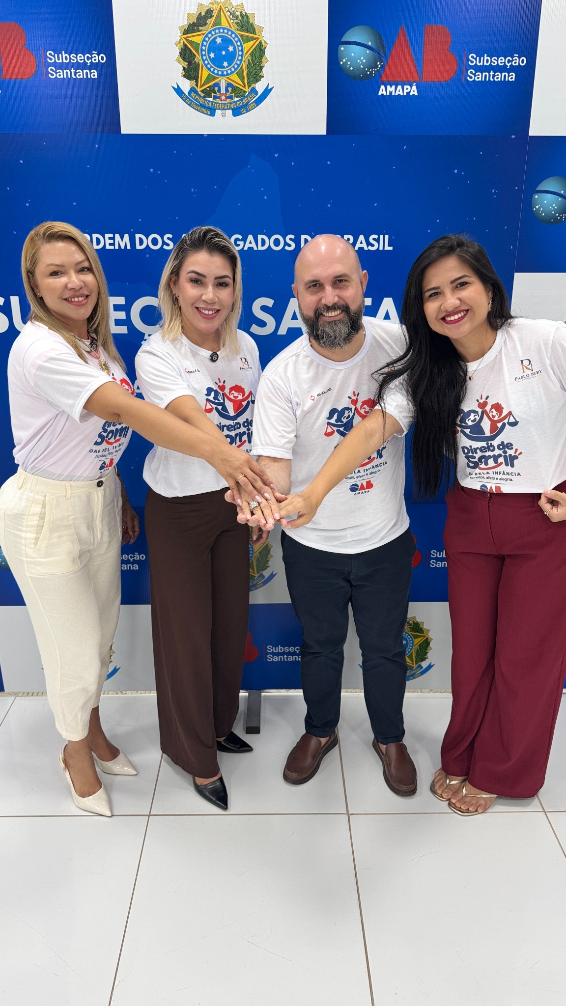 Registro de divulgação do projeto Direito de Sorrir, com quatro participantes usando camisetas da iniciativa na OAB Subseção Santana.